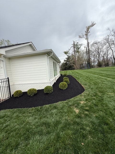 After spring cleanup in Brentwood TN with pruned perennials, trimmed shrubs, freshly mowed lawn, and premium black mulch installed
