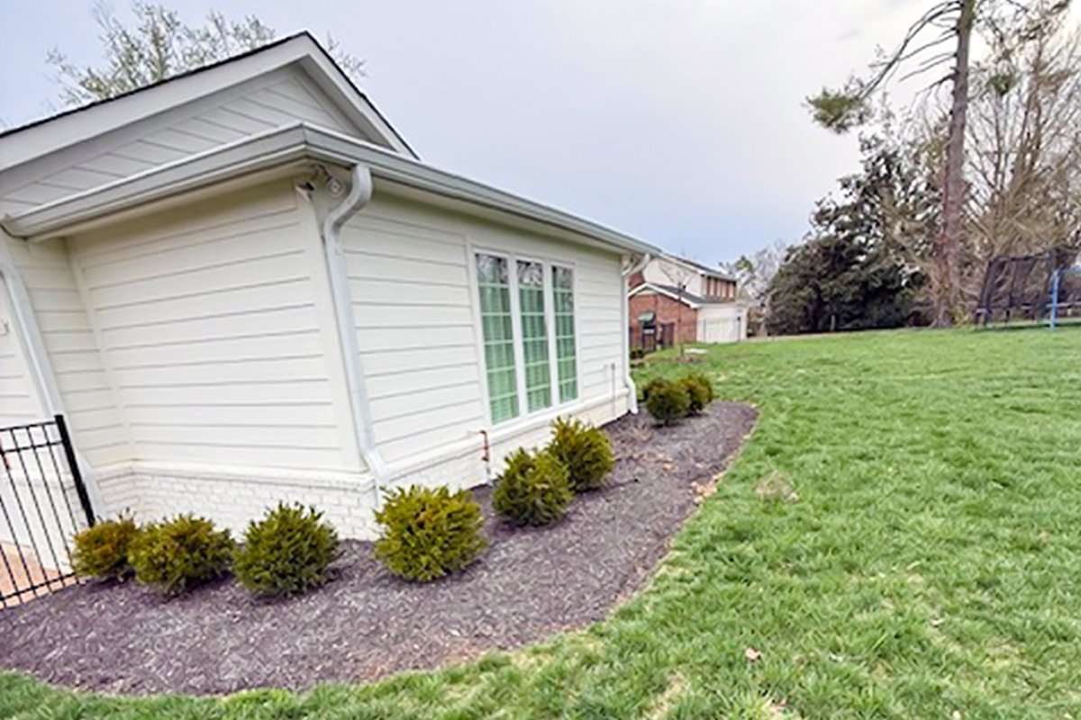 Before spring cleanup in Brentwood TN showing overgrown perennials, untrimmed shrubs, and no mulch installed